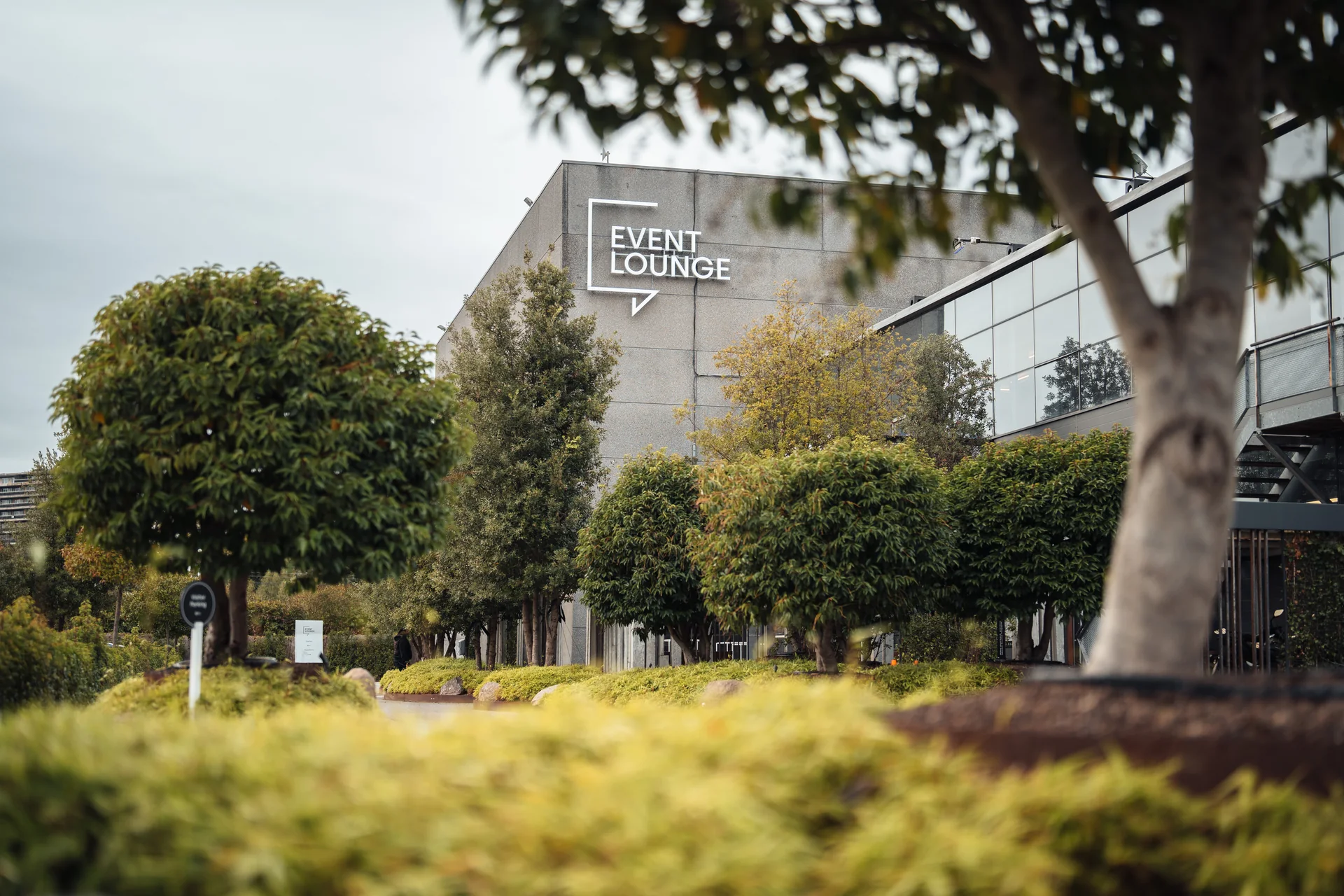 The Event Lounge building surrounded by trees and greenery